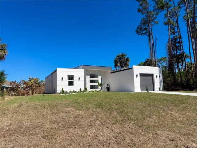 Contemporary home featuring a front yard and stucco siding