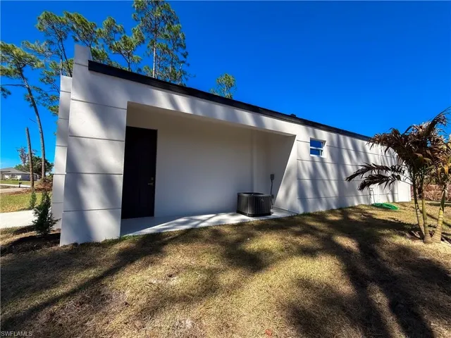 Back of property with stucco siding and a yard