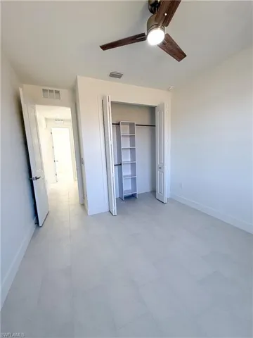 Guest bedroom featuring a closet, a ceiling fan, and light floors