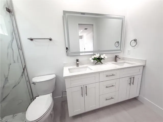 Master Bathroom with double vanity and a marble finish shower
