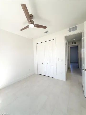 Guest bedroom featuring a ceiling fan and a closet