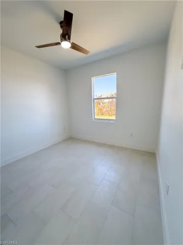 Spare room with baseboards and a ceiling fan