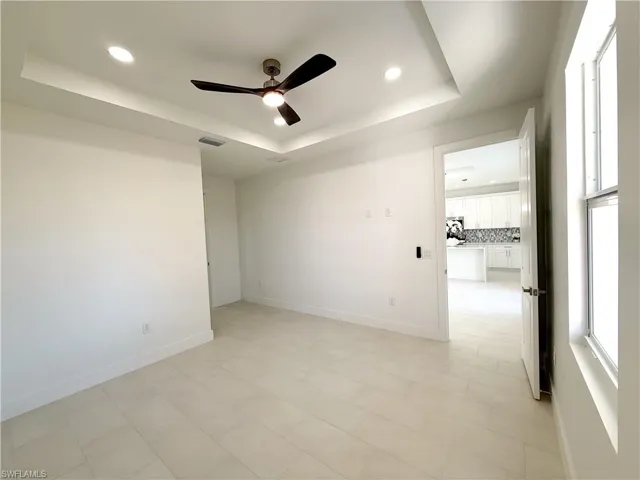 Master bedroom with a ceiling fan, recessed lighting, and a raised ceiling