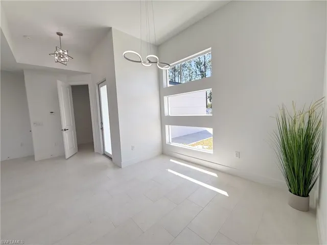 Unfurnished dining area with a chandelier and a high ceiling