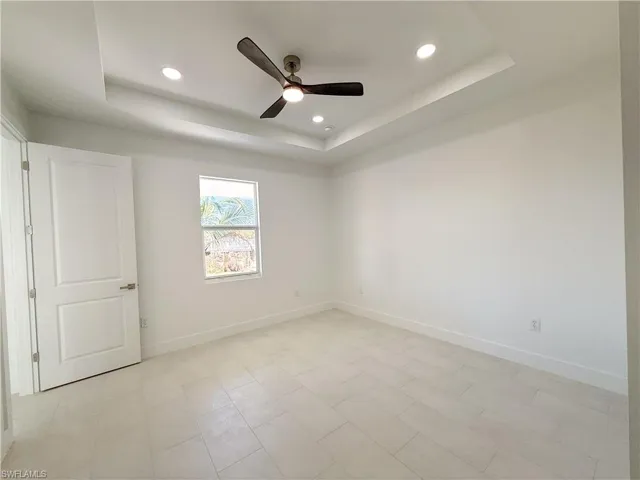 Master bedroom with ceiling fan, recessed lighting, and a tray ceiling