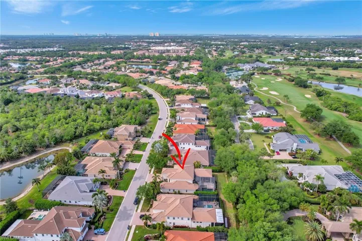 Drone / aerial view with view of golf course, a residential view, and a water view