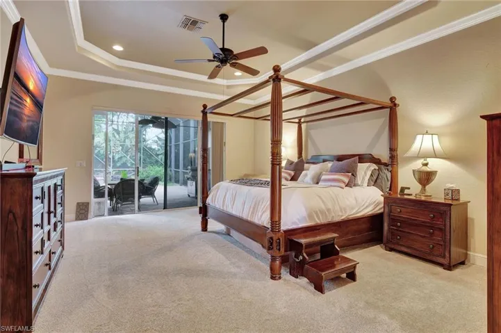 Bedroom with access to exterior, visible vents, crown molding, and a raised ceiling
