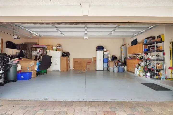 Garage featuring water heater and a garage door opener