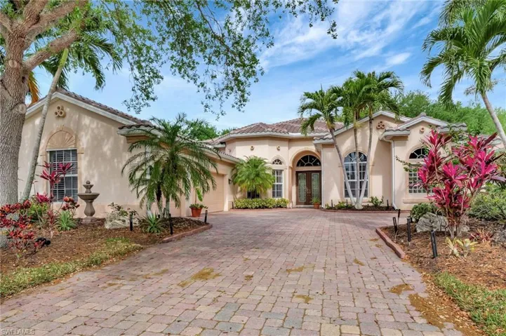 Mediterranean / spanish-style house featuring a tiled roof, decorative driveway, a garage, stucco siding, and french doors