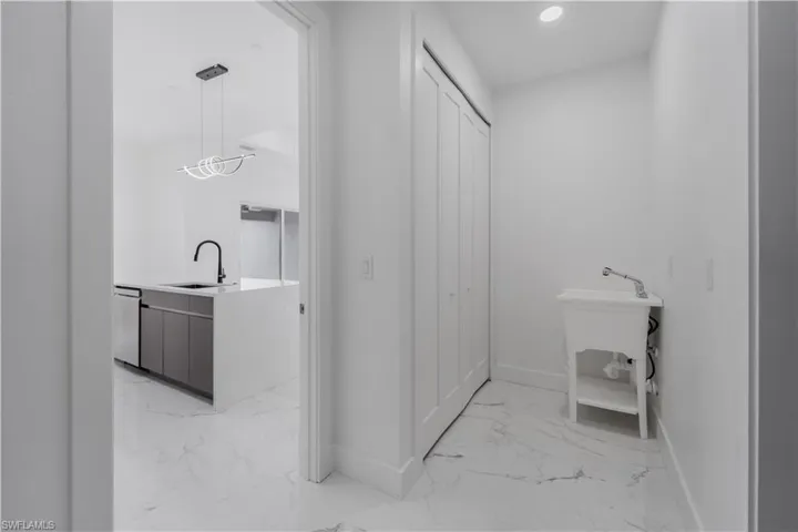 Bathroom featuring baseboards, marble finish floor, vanity, a closet, and recessed lighting