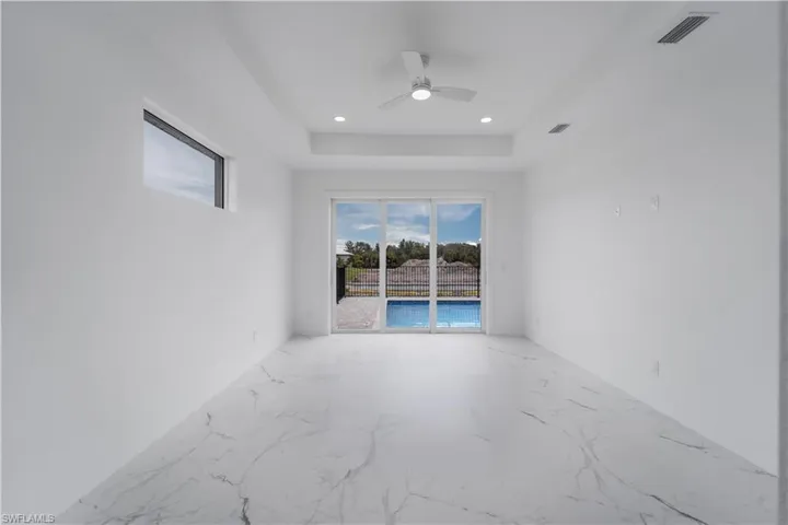Spare room featuring marble finish floor, recessed lighting, a raised ceiling, visible vents, and baseboards
