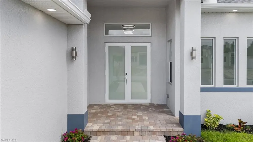 Doorway to property featuring french doors and stucco siding