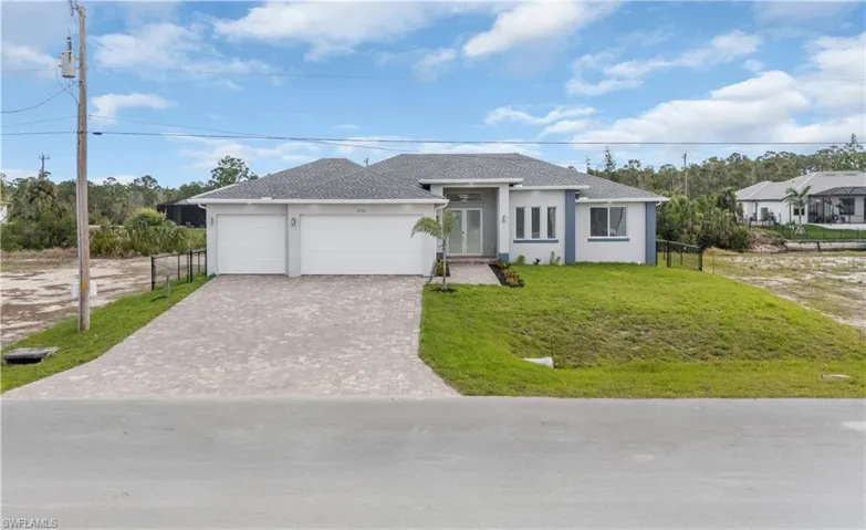 Single story home featuring a garage, fence, decorative driveway, a front lawn, and stucco siding