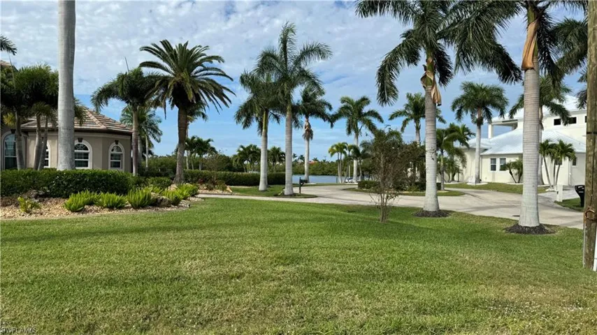 View of home's community with a water view and a yard