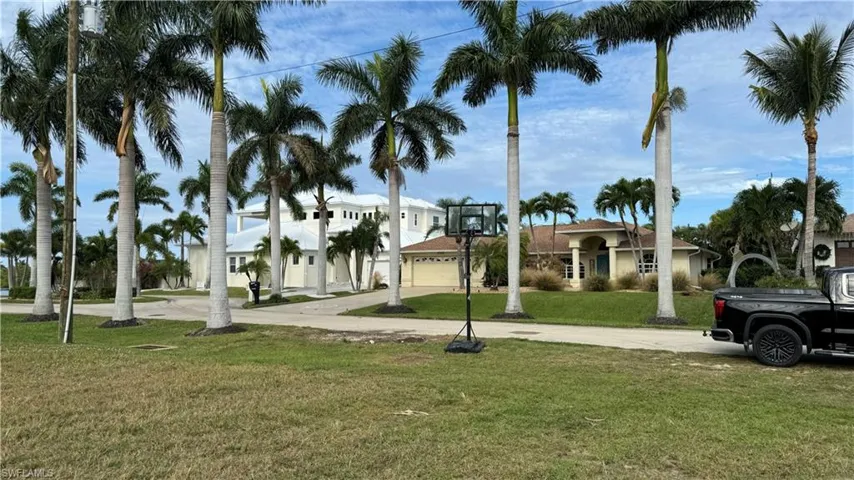 Surrounding community with driveway, a yard, and an attached garage