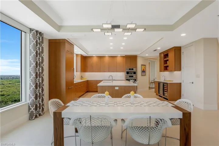 Matching quartz backsplash runs fromcountertop to bottom of cabinetry along allkitchen walls.