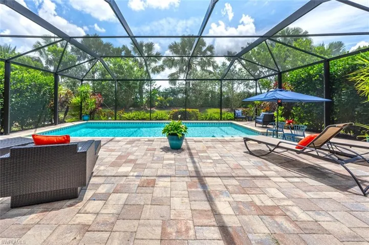 View of pool with a patio and glass enclosure