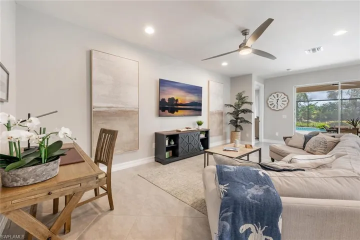 Living room with light tile patterned flooring and ceiling fan