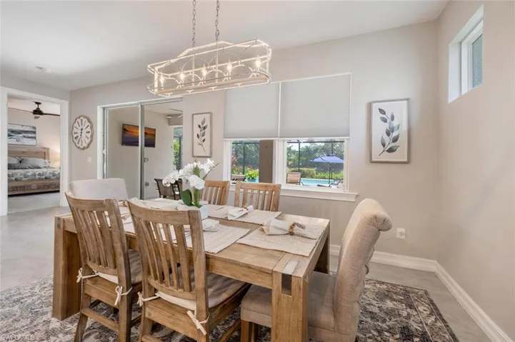 Tiled dining area with ceiling fan with notable chandelier