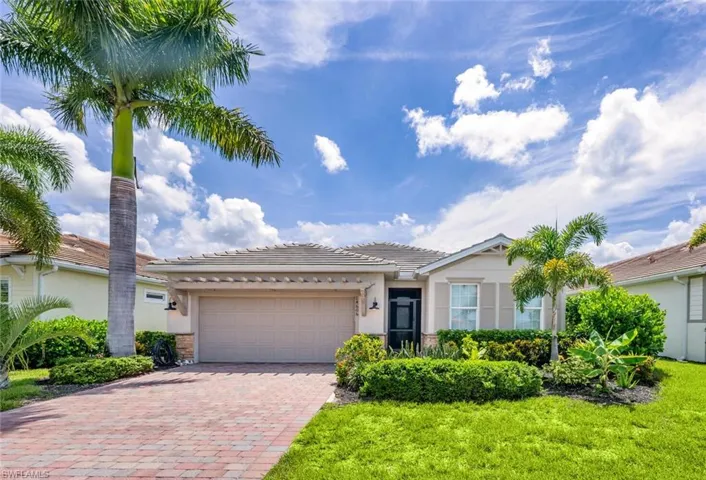View of front of property featuring a garage and a front lawn