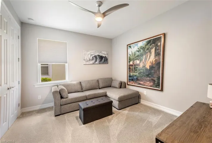 Carpeted living room featuring ceiling fan
