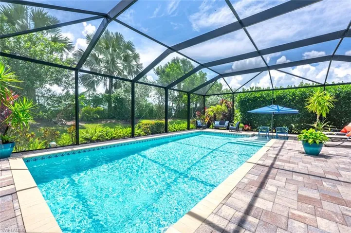 View of swimming pool with a patio area and glass enclosure