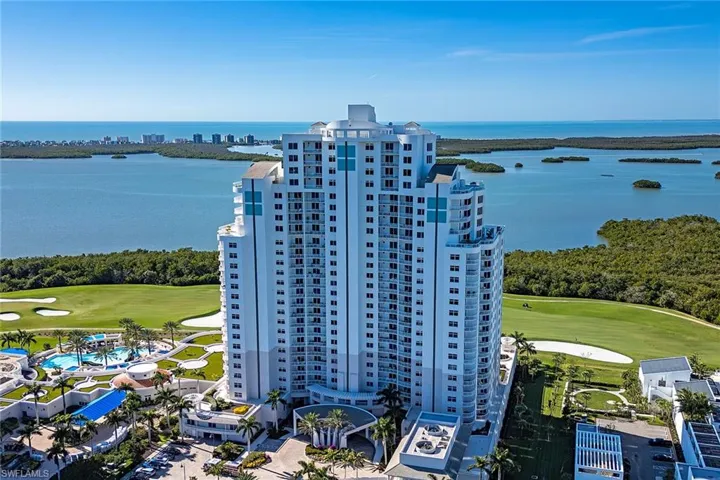 Drone / aerial view of apartment complex and a local golf course