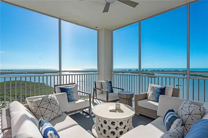 Sunroom / solarium with a water view and a wall of windows