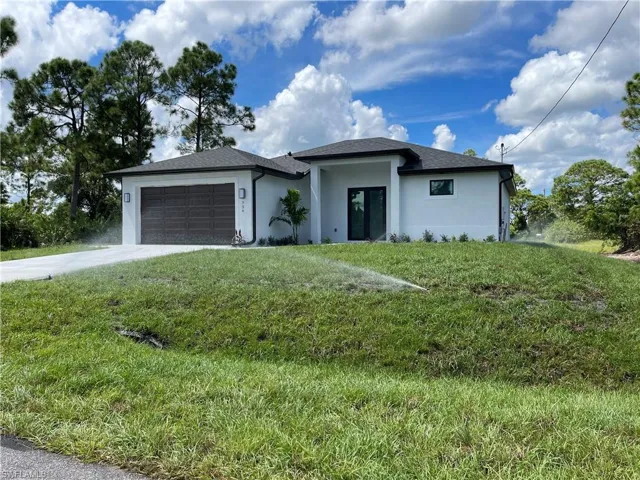 View of front of house featuring a front lawn and a garage