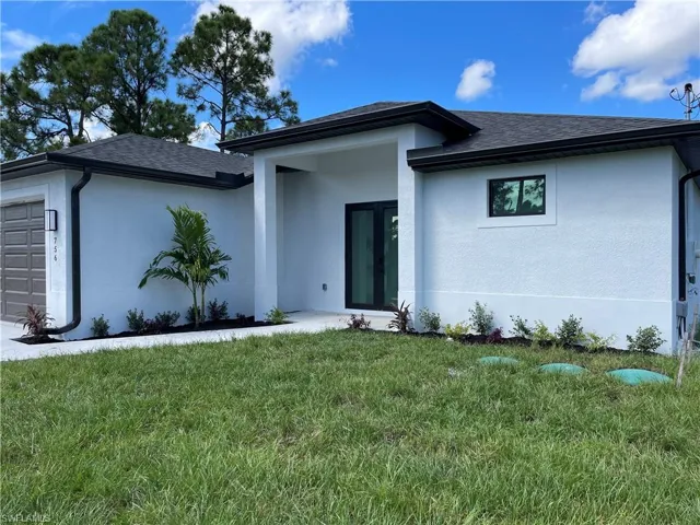 View of front of home with a front lawn and a garage