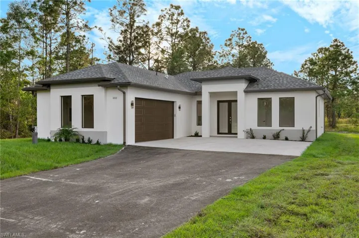 Prairie-style home with french doors, a front lawn, and a garage