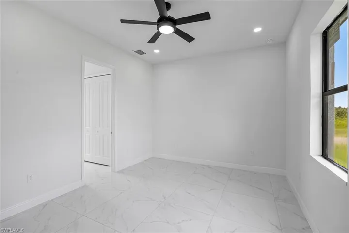 Spare room with light marble finish flooring, a ceiling fan, and recessed lighting