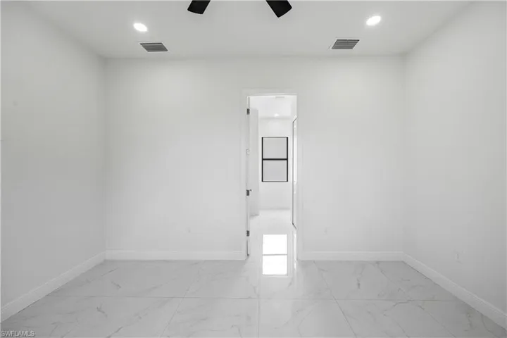 Empty room featuring light marble finish flooring, a ceiling fan, and recessed lighting
