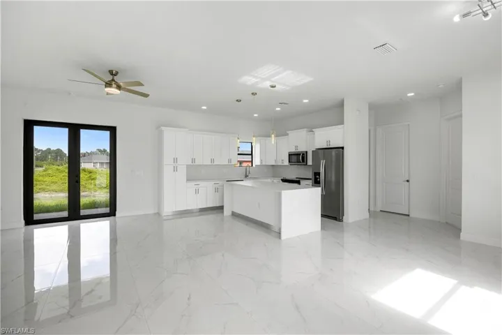 Kitchen featuring a center island, stainless steel appliances, healthy amount of natural light, and a ceiling fan