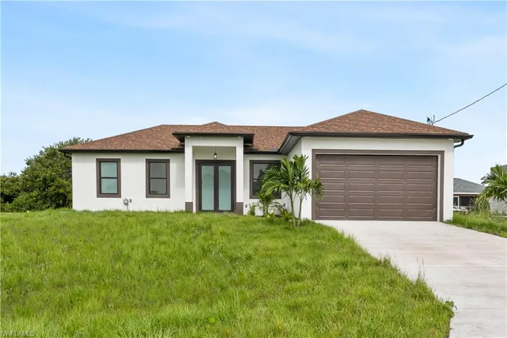 featuring a garage, concrete driveway, stucco siding, a front lawn, and roof with shingles