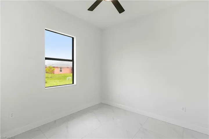 Unfurnished room with light marble finish flooring and a ceiling fan