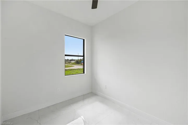 Unfurnished room with light marble finish flooring and ceiling fan