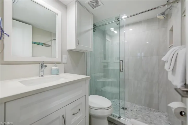Full bathroom with vanity and a shower stall
