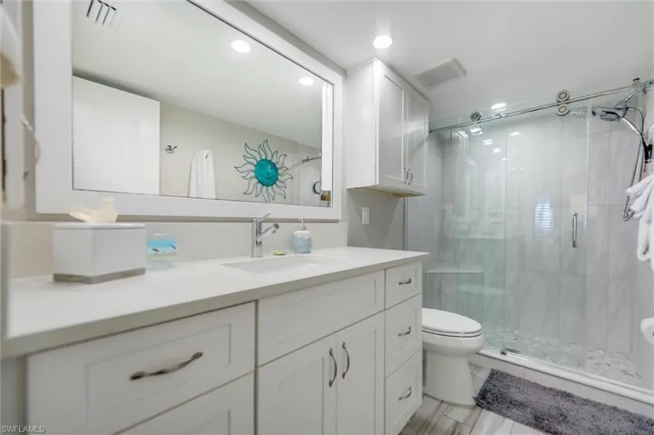 Full bathroom featuring vanity, a stall shower, and recessed lighting