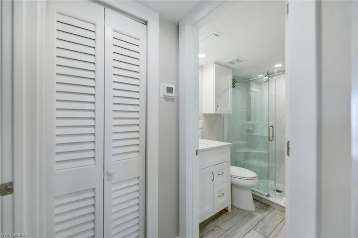 Full bathroom with a closet, vanity, a stall shower, and recessed lighting
