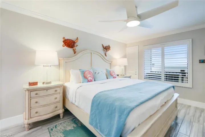 Bedroom with crown molding, a ceiling fan, and light wood finished floors