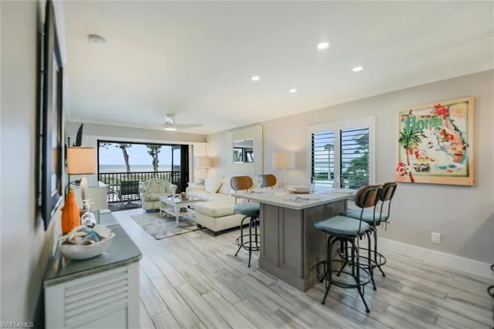 Living room with crown molding, recessed lighting, plenty of natural light, and light wood-style floors
