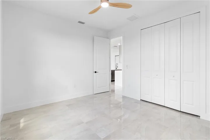 Unfurnished bedroom with a closet, baseboards, ceiling fan, and visible vents