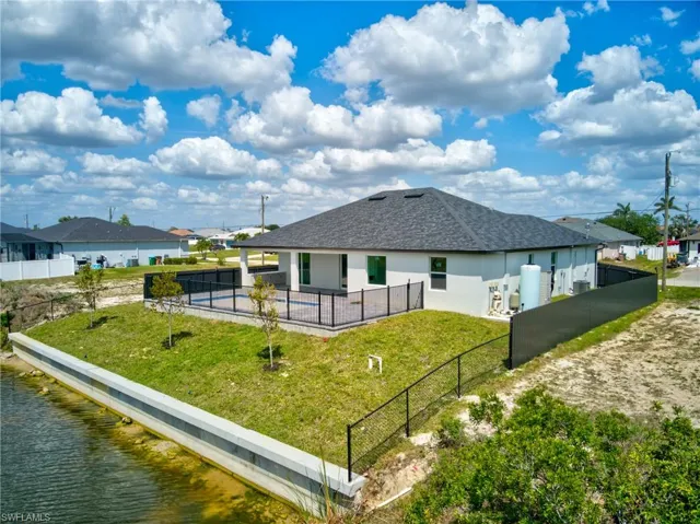 Back of property with a patio, fence, and a lawn