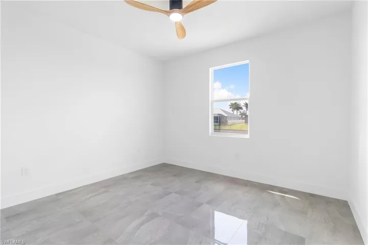 Empty room featuring baseboards and a ceiling fan