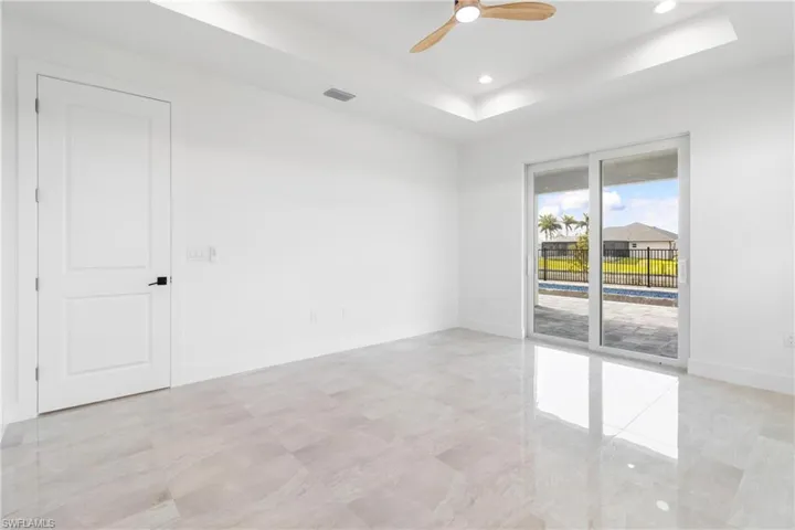Spare room with visible vents, baseboards, a ceiling fan, a tray ceiling, and recessed lighting