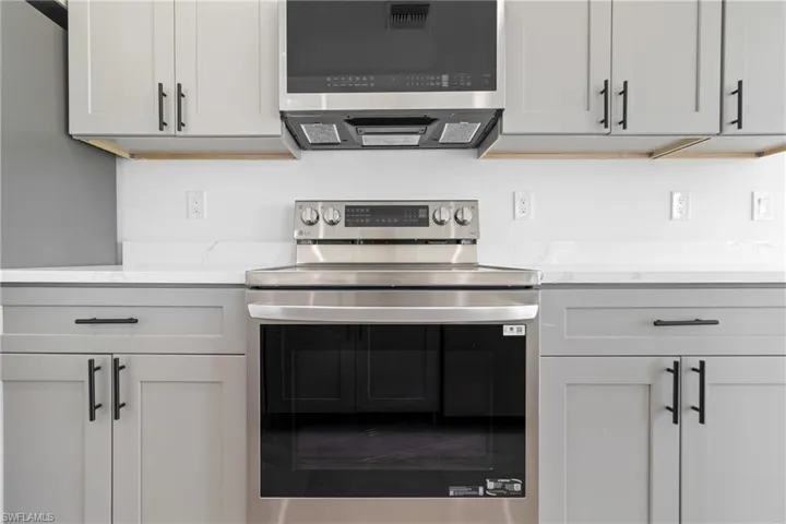 Kitchen with light stone counters and stainless steel appliances
