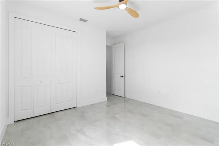 Unfurnished bedroom with a closet, ceiling fan, baseboards, and visible vents