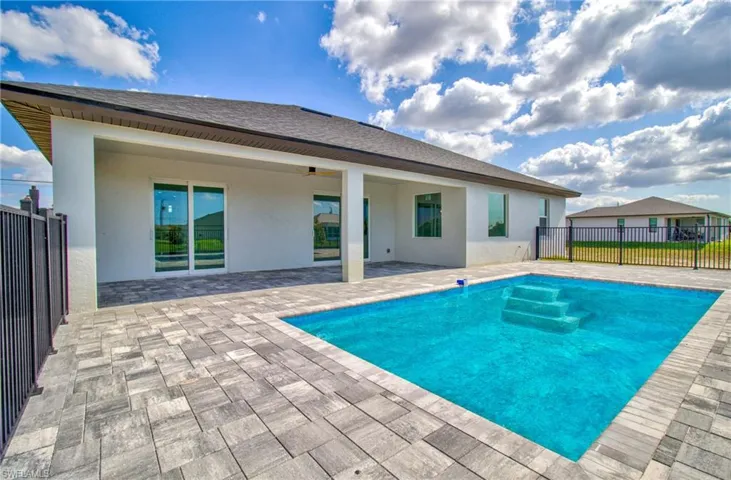 View of pool with fence, a patio, and a ceiling fan