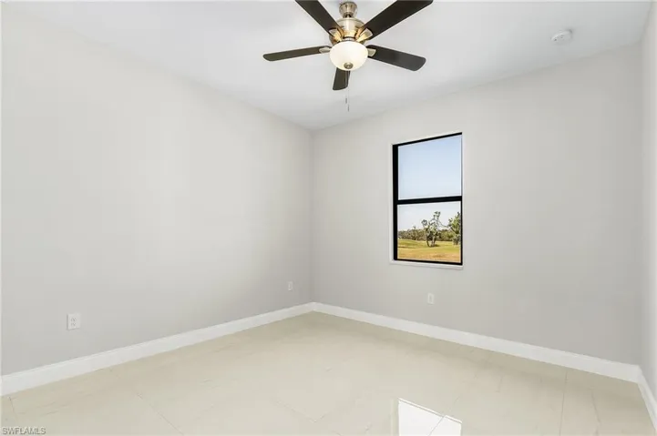 Empty room featuring ceiling fan and light tile patterned flooring